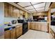 Kitchen featuring wood cabinets, black appliances, white countertops, and tiled flooring at 11109 Sumner Rd, Wimauma, FL 33598