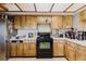 Kitchen with wood cabinets, black stove, white countertops, and stainless steel refrigerator at 11109 Sumner Rd, Wimauma, FL 33598