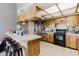 Kitchen featuring a breakfast bar, stainless steel refrigerator, black stove, and wood cabinets at 11109 Sumner Rd, Wimauma, FL 33598