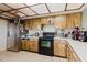 Spacious kitchen with wood cabinets, white countertops, stainless steel refrigerator, and black stove at 11109 Sumner Rd, Wimauma, FL 33598