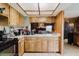 Cozy kitchen with warm wood cabinets, white countertops, and a view into the living room at 11109 Sumner Rd, Wimauma, FL 33598
