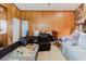Living room with wood paneling, tile flooring, and access to a kitchen space at 11109 Sumner Rd, Wimauma, FL 33598