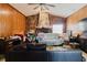 Cozy living room with stone fireplace, wood paneling, tile flooring, and comfortable sofas at 11109 Sumner Rd, Wimauma, FL 33598