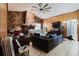 Cozy living room with stone fireplace, wood paneling, tile flooring, and comfortable seating at 11109 Sumner Rd, Wimauma, FL 33598
