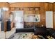 Living room with wood paneling, tile flooring, and view into kitchen area at 11109 Sumner Rd, Wimauma, FL 33598