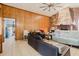 Living room featuring a stone fireplace, wood paneling, and access to another room at 11109 Sumner Rd, Wimauma, FL 33598
