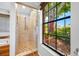 Bathroom featuring walk-in shower with mosaic tile floor and a view of the landscaped backyard at 1111 Chatham Ct, Safety Harbor, FL 34695