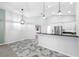 Open dining area with decorative lighting, tile floors, and a partial view into the kitchen at 1111 Chatham Ct, Safety Harbor, FL 34695
