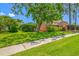 Well-maintained exterior with lush landscaping, mature trees, and a green lawn at 1111 Chatham Ct, Safety Harbor, FL 34695
