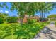 Landscaped home exterior with mature trees, green lawn, and a tidy walkway at 1111 Chatham Ct, Safety Harbor, FL 34695