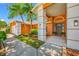 Inviting home entrance showcasing an orange facade, well-manicured lawn, and decorative columns at 1111 Chatham Ct, Safety Harbor, FL 34695