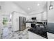 Kitchen with stainless steel appliances, granite counters, and white cabinets, next to laundry area at 1111 Chatham Ct, Safety Harbor, FL 34695