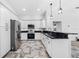 Kitchen with stainless appliances, granite counters, white cabinets, and decorative hanging light fixtures at 1111 Chatham Ct, Safety Harbor, FL 34695