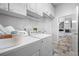 Bright laundry area featuring updated machines, cabinet storage, and tiled floors at 1111 Chatham Ct, Safety Harbor, FL 34695