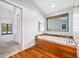 Relaxing main bath with a soaking tub and wood-look tile flooring at 1111 Chatham Ct, Safety Harbor, FL 34695