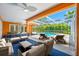 Relaxing outdoor patio with comfortable seating, overlooking a sparkling screened-in pool and lush greenery at 1111 Chatham Ct, Safety Harbor, FL 34695