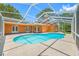 Sparkling in-ground pool surrounded by a screened enclosure, perfect for enjoying the outdoors in privacy at 1111 Chatham Ct, Safety Harbor, FL 34695
