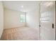 A bright, empty bedroom with neutral carpeting and a modern paneled door at 11303 Striped Bass Ct, New Port Richey, FL 34654