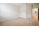 A bright bedroom with neutral carpet, light walls, and access to an adjacent bathroom at 11303 Striped Bass Ct, New Port Richey, FL 34654