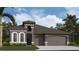 Single-Gathering home with a three-car garage and elegant arched window details at 11303 Striped Bass Ct, New Port Richey, FL 34654