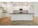 View of kitchen island with white cabinets, modern appliances and eat-in bar at 11303 Striped Bass Ct, New Port Richey, FL 34654