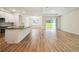 View of open floor plan with modern kitchen and bright living room with sliding glass door at 11303 Striped Bass Ct, New Port Richey, FL 34654