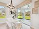 Bright dining area featuring modern chandelier, white table set, and sliding glass doors to private outdoor patio at 11324 Striped Bass Ct, New Port Richey, FL 34654