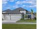 New home with a three-car garage, lush landscaping, and beautiful lawn at 11324 Striped Bass Ct, New Port Richey, FL 34654
