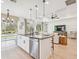 Open concept kitchen and living space featuring a center island, hardwood floors and lots of natural light at 11324 Striped Bass Ct, New Port Richey, FL 34654