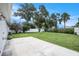 Lush backyard featuring a concrete patio area, mature trees, and a well-maintained lawn at 11416 126Th N Ave, Largo, FL 33778