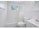 Bright bathroom featuring a shower-tub combo, crisp white tiling and fixtures, and a window for natural light at 11416 126Th N Ave, Largo, FL 33778