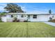 Charming single-story home with a well-manicured lawn, blue shutters, and a freshly painted exterior at 11416 126Th N Ave, Largo, FL 33778