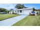 Well-maintained single-story home with an attached garage and a blue driveway at 11416 126Th N Ave, Largo, FL 33778