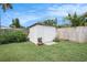 Backyard storage shed offering additional space, surrounded by green grass and foliage at 11416 126Th N Ave, Largo, FL 33778