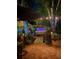 Relaxing backyard with a hot tub, brick patio, lush landscaping, and ambient lighting for evening enjoyment at 11760 Ashley Ct, Seminole, FL 33772