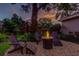 Inviting backyard seating area with a fire pit and lush landscaping under a sunset sky at 11760 Ashley Ct, Seminole, FL 33772