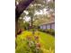 Lush backyard with manicured lawn, vibrant flowers, and mature trees creating a serene outdoor space at 11760 Ashley Ct, Seminole, FL 33772
