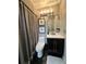 Charming bathroom featuring modern lighting, framed artwork, dark vanity, and sleek fixtures with a shower/tub combination at 11760 Ashley Ct, Seminole, FL 33772