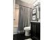 Stylish bathroom featuring a vanity, toilet, framed artwork, and a shower/tub combination with a gray shower curtain at 11760 Ashley Ct, Seminole, FL 33772