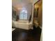 Bathroom featuring soaking tub with white tiled surround and chandelier at 11760 Ashley Ct, Seminole, FL 33772