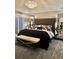 Comfortable bedroom with king-size bed, mirrored nightstands, and a modern crystal chandelier at 11760 Ashley Ct, Seminole, FL 33772