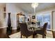 Sophisticated dining room with stylish chairs, glass table, dark wood floors, and elegant chandelier at 11760 Ashley Ct, Seminole, FL 33772
