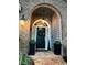 Elegant front door with brick archway, decorative wreath, and classic outdoor lighting at 11760 Ashley Ct, Seminole, FL 33772