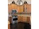 Well-equipped kitchen with stainless steel appliances, wooden cabinets, and granite countertops at 11760 Ashley Ct, Seminole, FL 33772