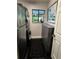 Functional laundry room boasts modern washer/dryer, sleek cabinetry, and a window with natural light and greenery at 11760 Ashley Ct, Seminole, FL 33772