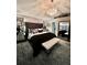 Luxurious main bedroom with elegant chandelier, tufted headboard, mirrored accents, and a stylish white bench at 11760 Ashley Ct, Seminole, FL 33772