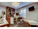 Elegant home office featuring a custom built-in bookcase, a glass-top desk, and plantation shutters for natural light at 11760 Ashley Ct, Seminole, FL 33772
