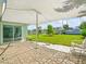 Waterfront backyard featuring a covered patio, lush lawn, and sliding door entry to the home at 13316 Carol Dr, Hudson, FL 34667