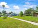 Scenic waterfront backyard with lush lawn, mature trees, and access to the canal at 13316 Carol Dr, Hudson, FL 34667