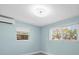 Well-lit bedroom features updated lighting and dual windows showing views of the property at 13316 Carol Dr, Hudson, FL 34667